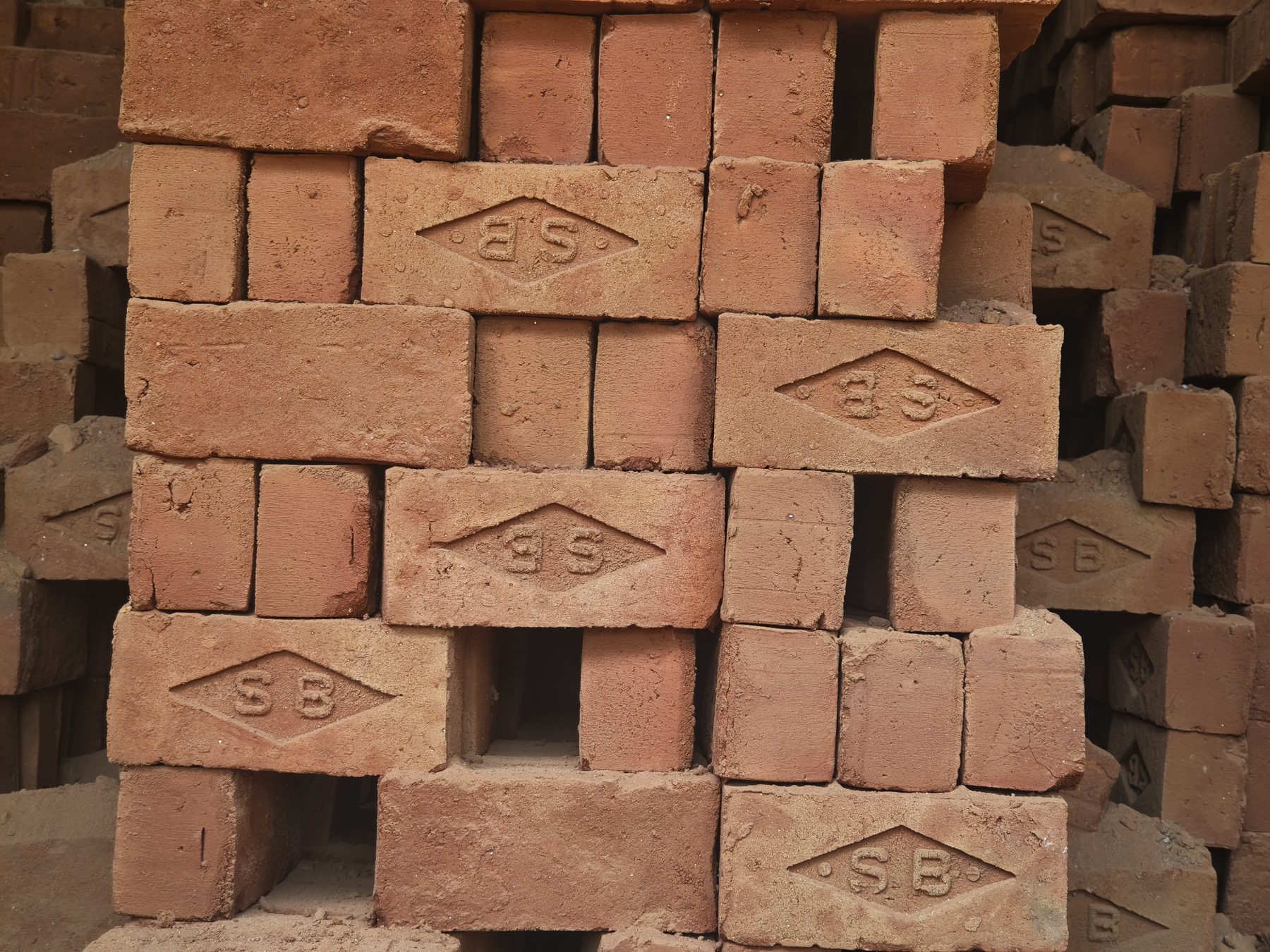 Stacked SB-branded red bricks ready for dispatch